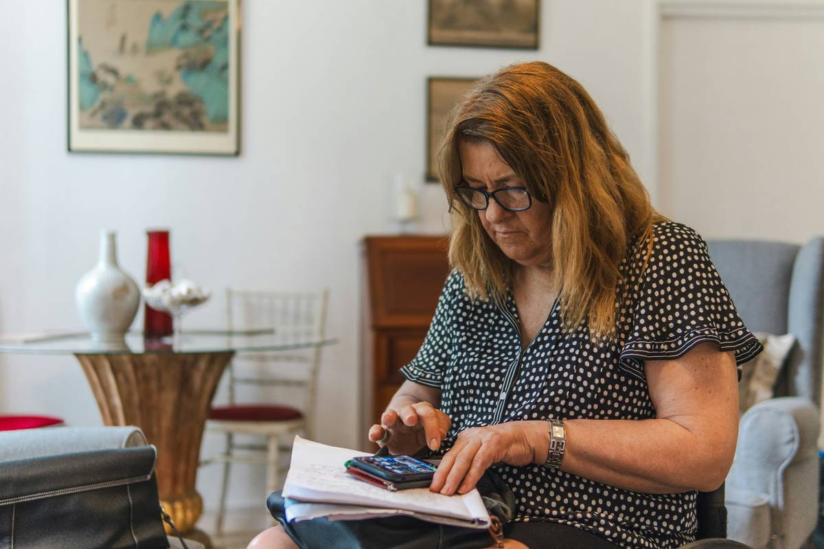 woman reviewing grant application documents with laptop showing women in business grants search results